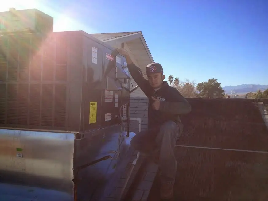 HVAC technician performing AC Tune-Up on a rooftop unit in East Rockhill